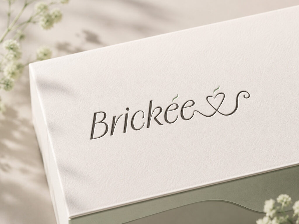 Geprägtes Brickée-Logo auf hochwertigem weißem Papier mit feinen grünen Akzenten.